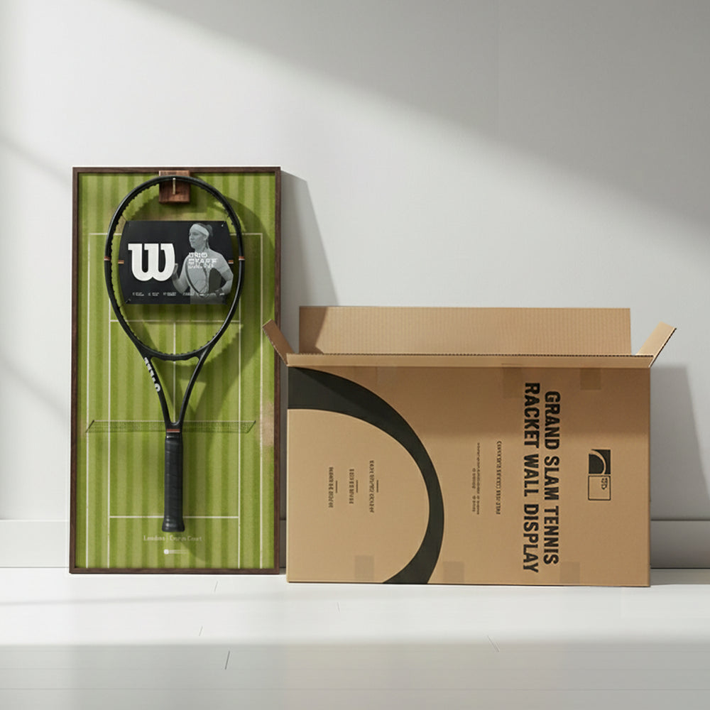 The Wimbledon-themed ONE MAAY tennis racket wall display leaning against a white wall next to its open Grand Slam shipping box