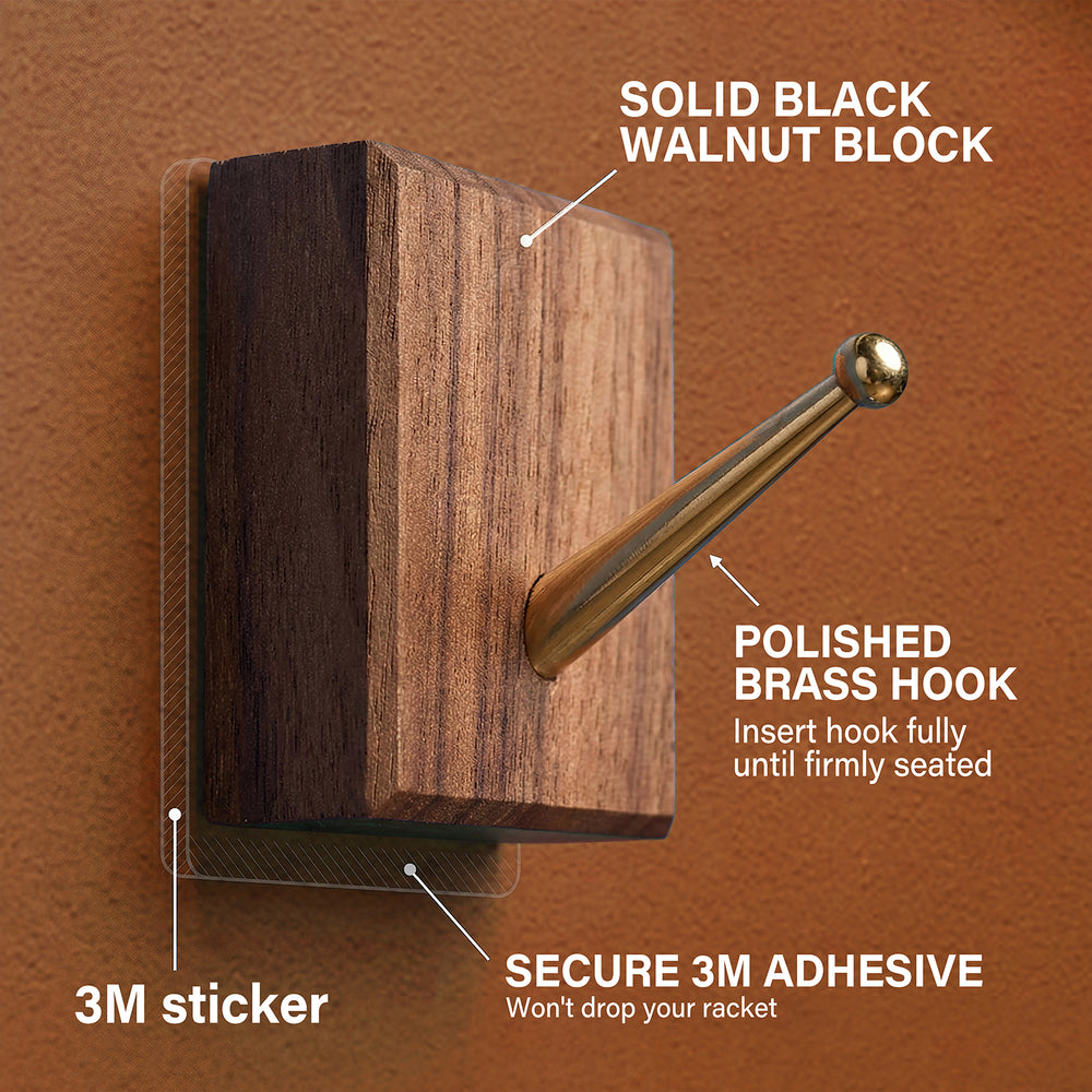 Detailed view of the solid black walnut block and polished brass hook with secure 3M adhesive used for mounting the racket on the ONE MAAY display.