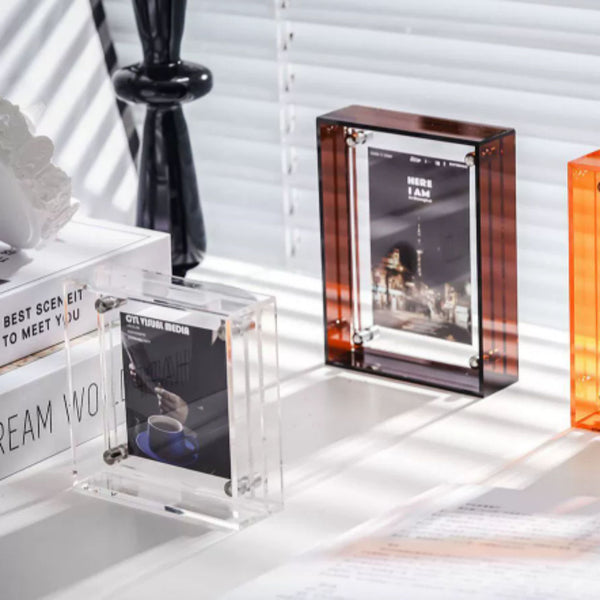 Clear and transparent photo frames on a white surface with blurred background