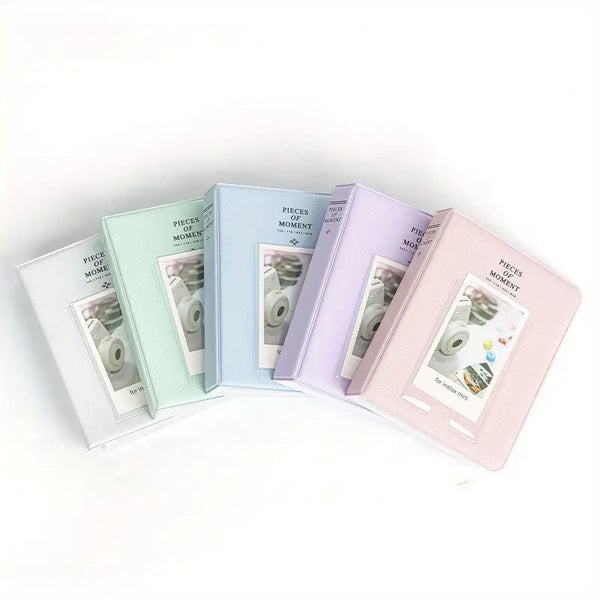 Set of five small photo albums in pastel colors on a white background